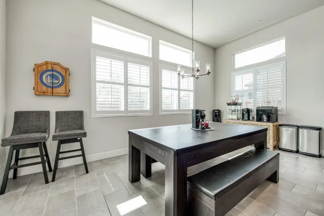 a room with a table chairs and a window