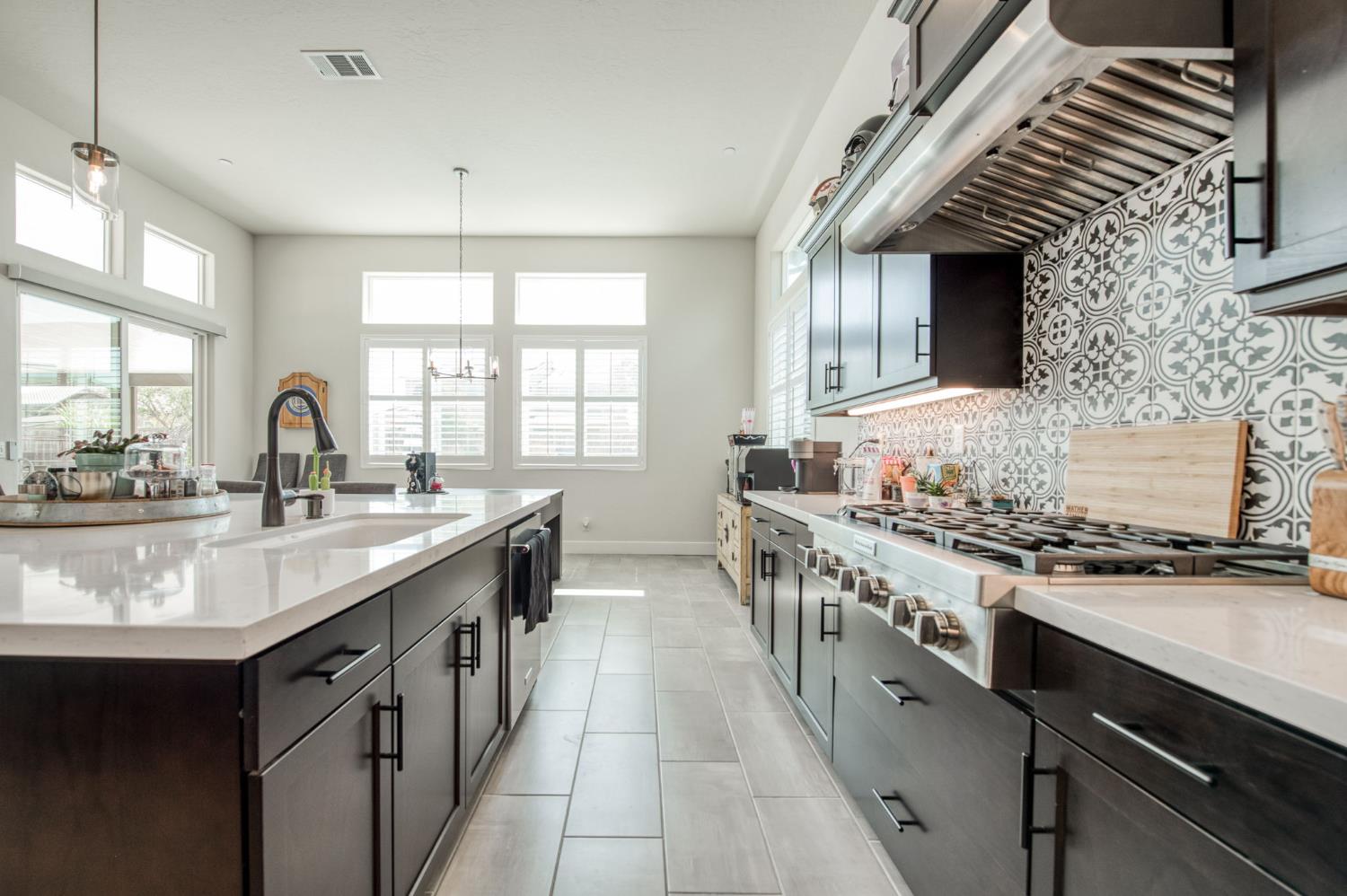 1020 Highland Road Madera, CA 93636 - Photo 14 of 42 a kitchen with stainless steel appliances granite countertop a sink stove and cabinets