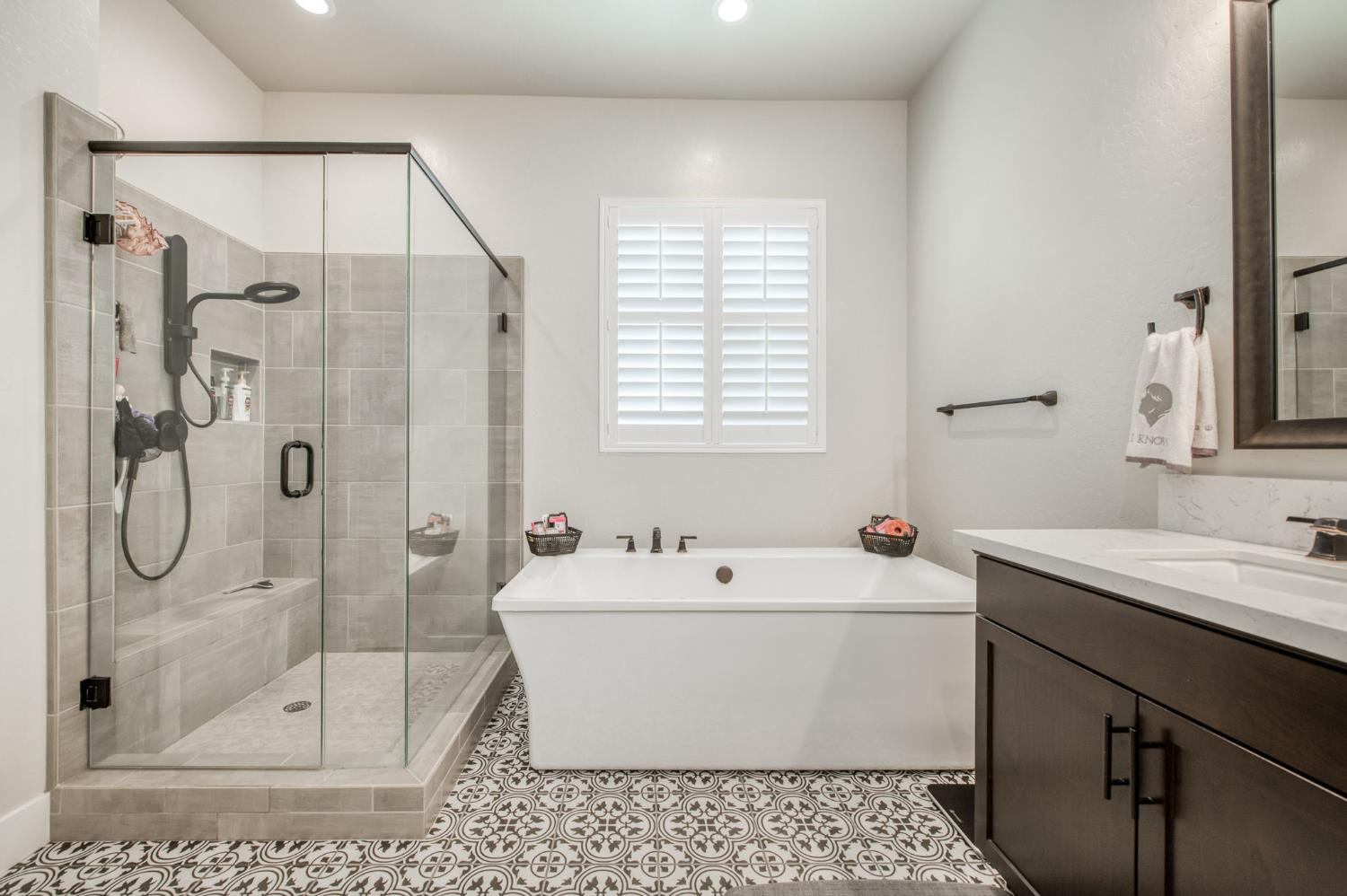 1020 Highland Road Madera, CA 93636 - Photo 20 of 42 a bathroom with a sink a mirror a glass door and shower