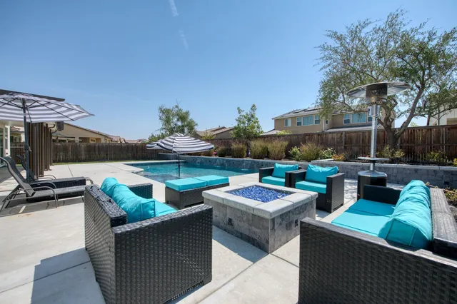 a view of a house with pool and chairs