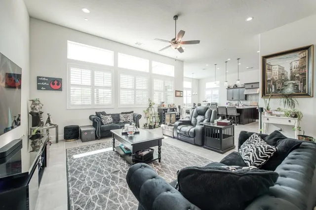a living room with furniture kitchen view and a large window