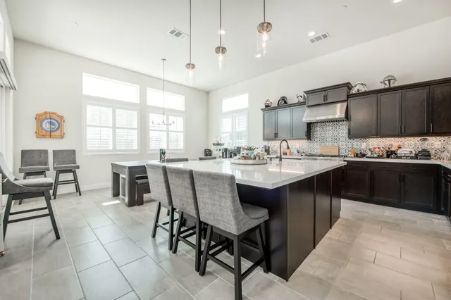 a kitchen with a sink and chairs