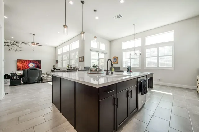 a kitchen with stainless steel appliances granite countertop a sink and a wooden floor