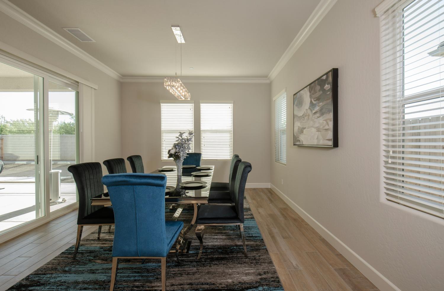 2120 North Perry Avenue Clovis, CA 93619 - Photo 16 of 37 a view of a dining room with furniture a chandelier and wooden floor