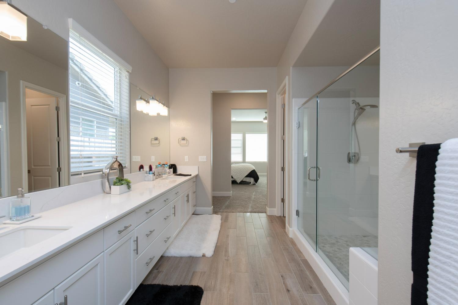 2120 North Perry Avenue Clovis, CA 93619 - Photo 23 of 37 a spacious bathroom with a double vanity sink a large mirror a bathtub and shower