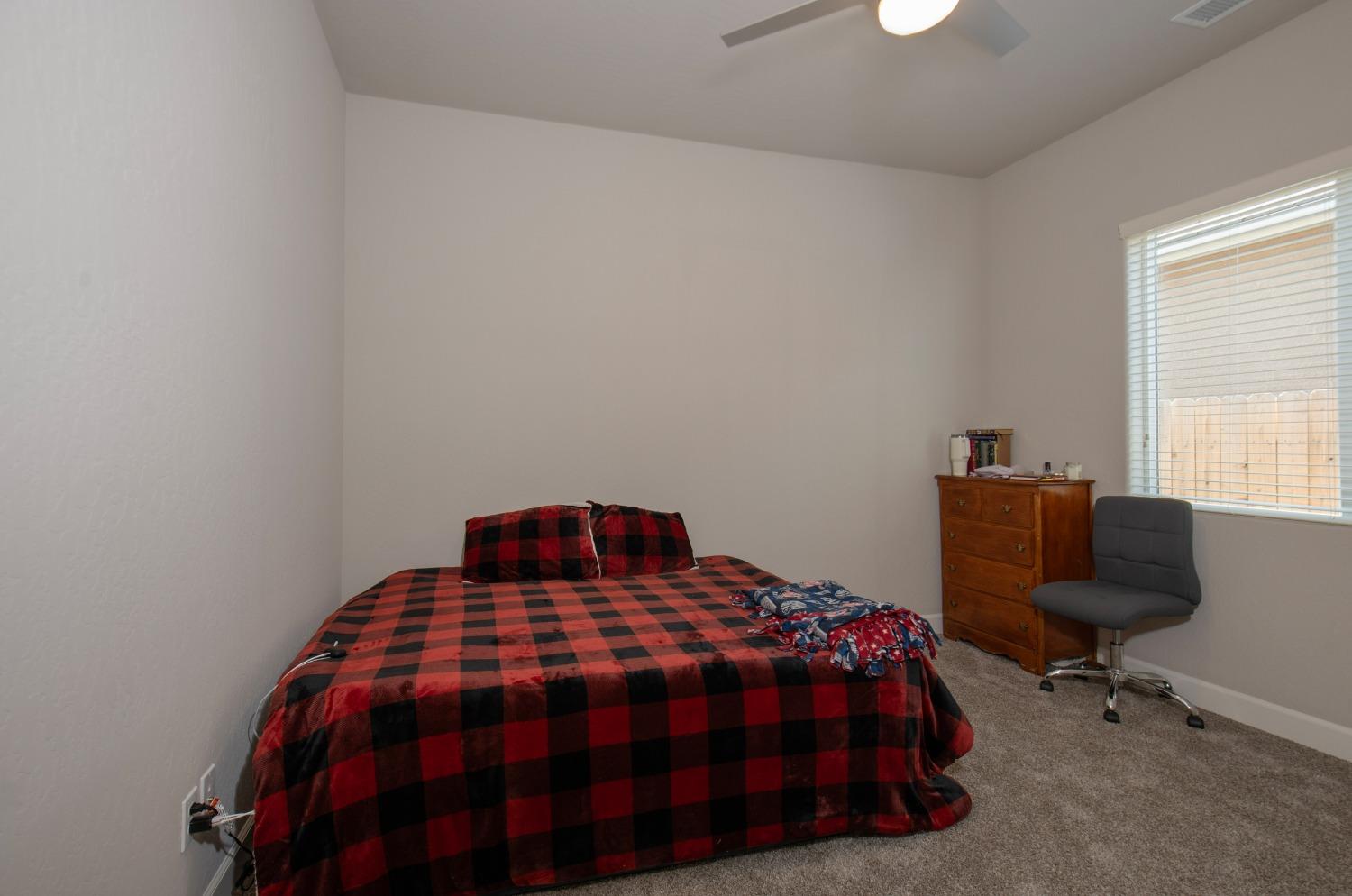 2120 North Perry Avenue Clovis, CA 93619 - Photo 27 of 37 a bedroom with a bed a chair and a window
