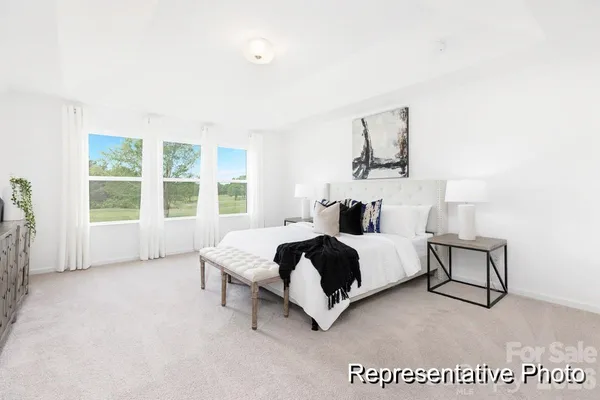 a spacious bedroom with a bed a window and walk in closet