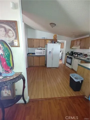 a kitchen with stainless steel appliances wooden floors and wooden cabinets