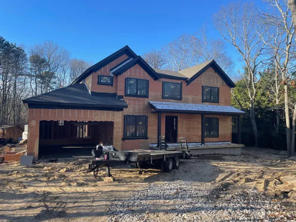 a front view of a house with yard and parking