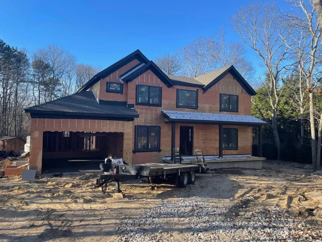 a front view of a house with yard and parking