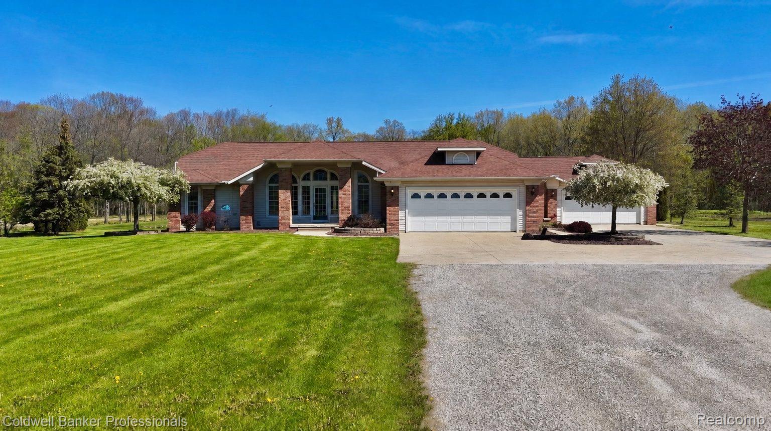 6464 Ferden Road Chesaning, MI 48616 - Photo 1 of 23 Ranch-style house with driveway, a front lawn, a garage, and brick siding