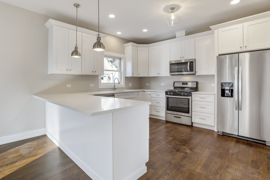 272 North Spring Street Elgin, IL 60120 - Photo 7 of 21 a kitchen with kitchen island a white counter top space stainless steel appliances and cabinets