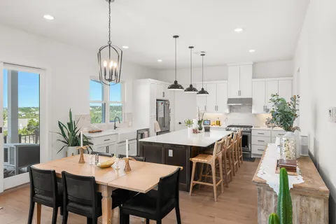 a dining table with chairs and kitchen view