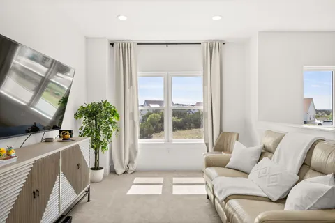 a hallway with white cabinets and wooden floor