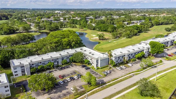 an aerial view of residential houses with outdoor space and parking