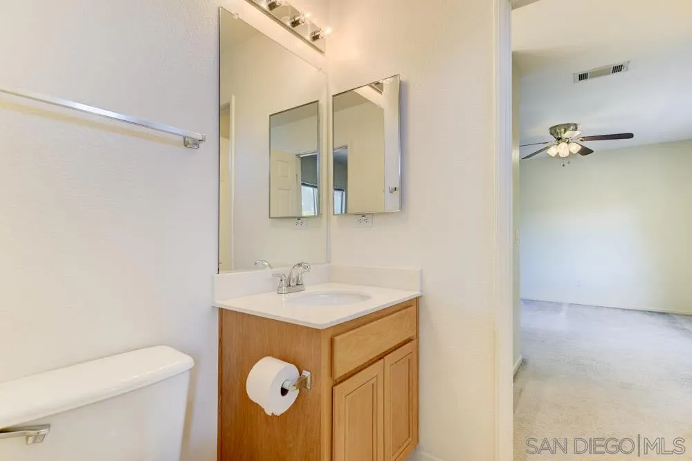 1397 Sunhaven Road Alpine, CA 91901 - Photo 24 of 26 a bathroom with a sink and mirror with toilet