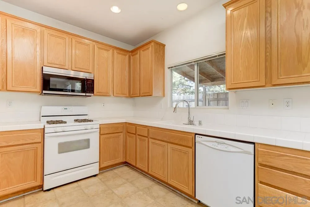 1397 Sunhaven Road Alpine, CA 91901 - Photo 5 of 26 a kitchen with stainless steel appliances granite countertop a sink a stove and a microwave