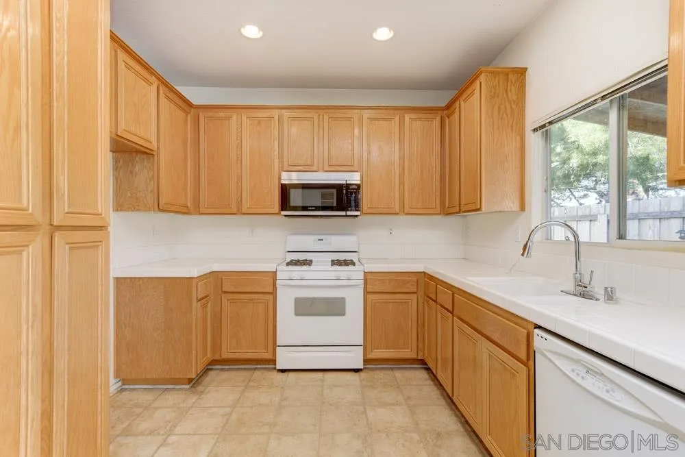 1397 Sunhaven Road Alpine, CA 91901 - Photo 6 of 26 a kitchen with stainless steel appliances granite countertop a stove a sink and a microwave