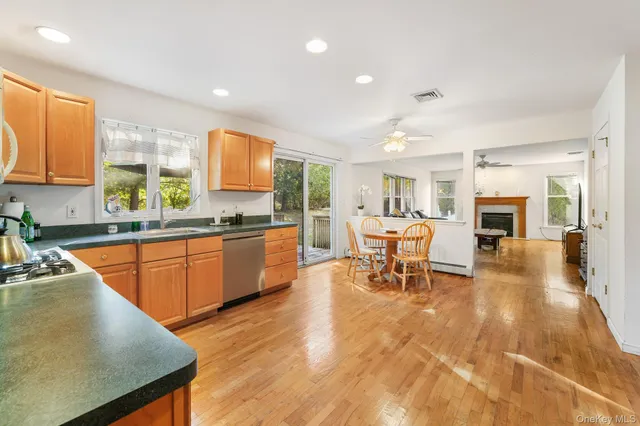 a kitchen with stainless steel appliances granite countertop sink stove and white cabinets with wooden floor