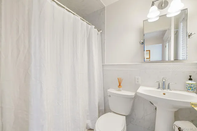 a bathroom with a sink a toilet and a mirror