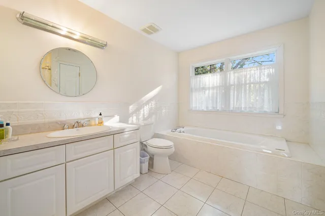 a bathroom with a granite countertop toilet a sink and a mirror