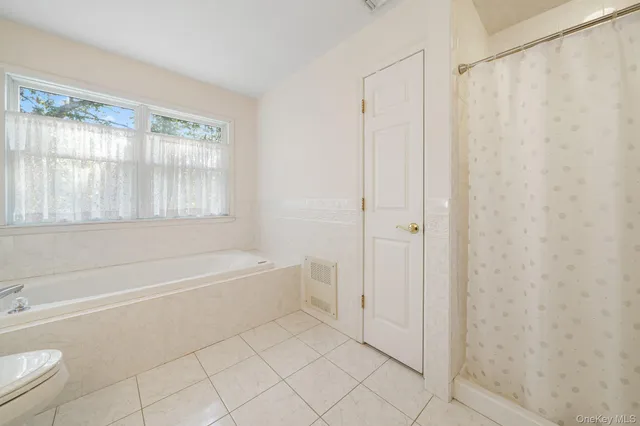 a spacious bathroom with a bathtub and a shower