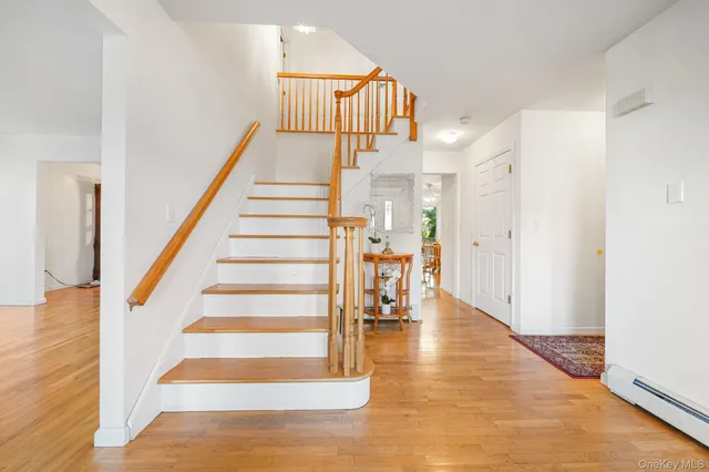 a view of entryway and hall with wooden floor
