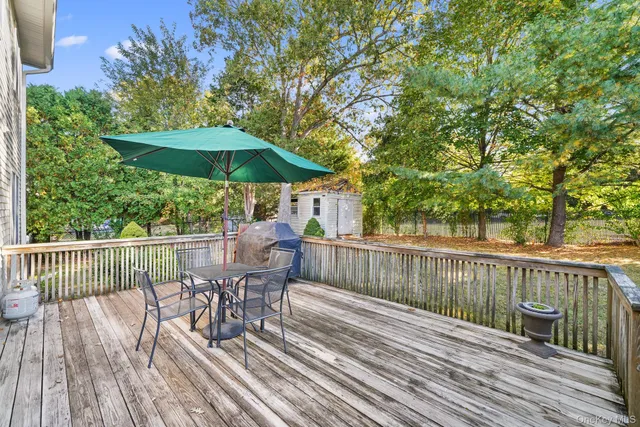 a view of deck with furniture and barbeque oven with wooden floor and fence