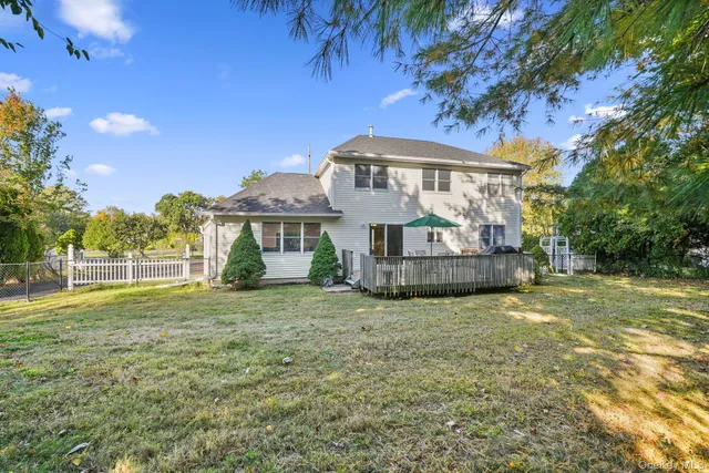 a view of a house with a big yard and large trees