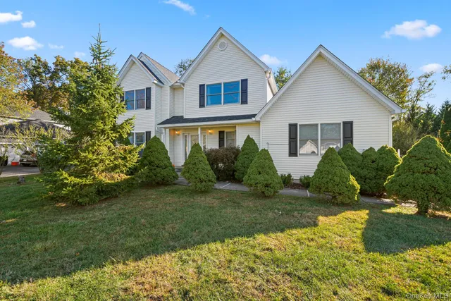a view of a house with a yard and potted plants