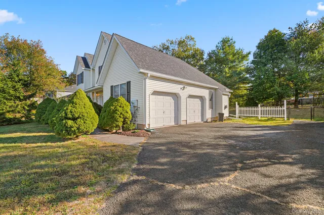 a view of a house with a yard and a large tree