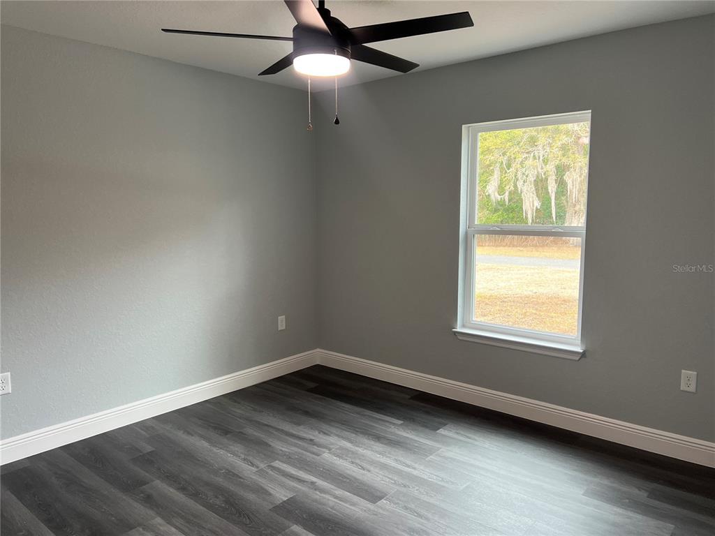 2512 Southwest 147 Place Road Ocala, FL 34473 - Photo 9 of 13 an empty room with wooden floor and windows