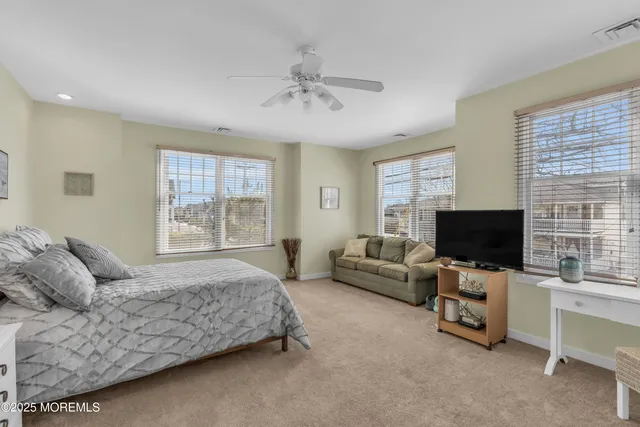 a spacious bedroom with a bed and a flat screen tv