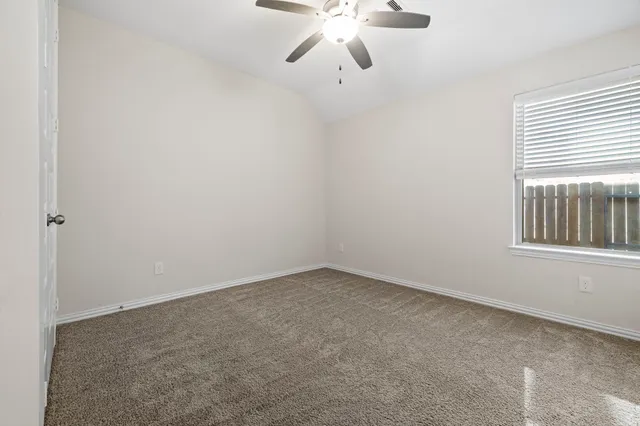 an empty room with chandelier fan