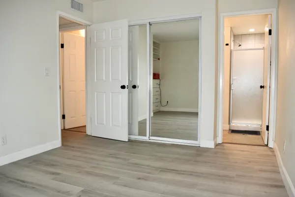 a view of an empty room with wooden floor
