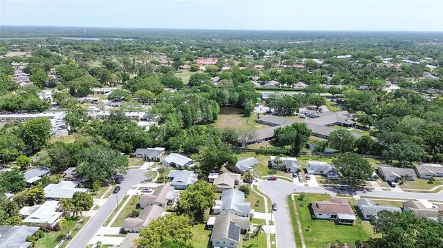 an aerial view of residential houses with outdoor space and trees