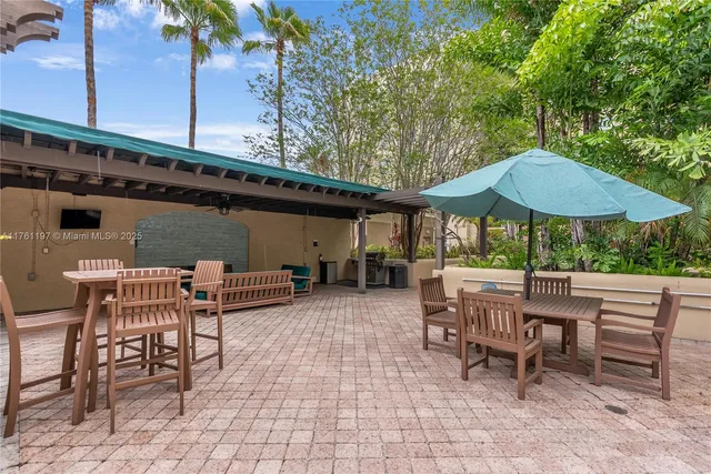 a view of a patio with a table and chairs under an umbrella