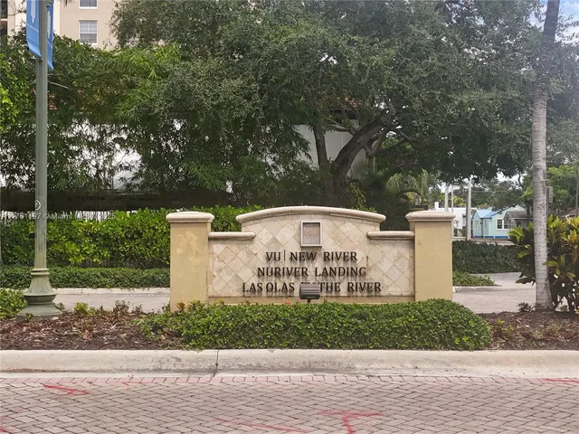 a view of a white house with a yard and large trees