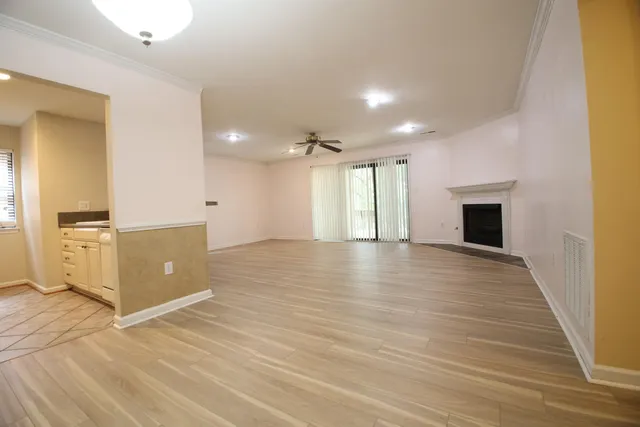 an empty room with wooden floor and windows
