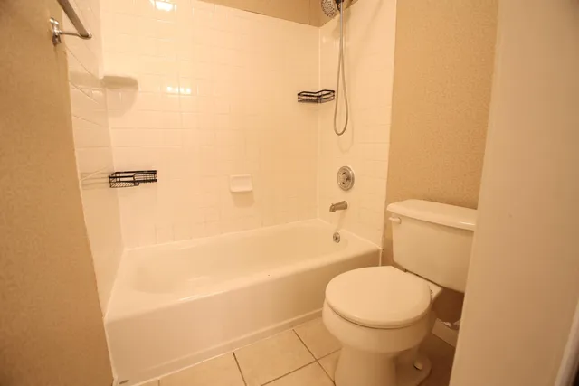 a white toilet sitting next to a bath tub