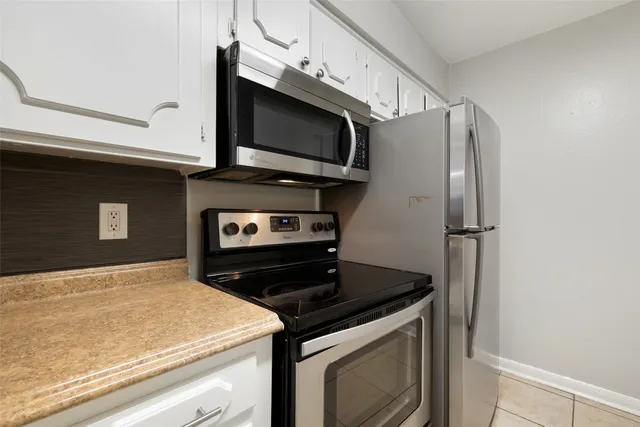 a kitchen with stainless steel appliances granite countertop a stove microwave and refrigerator