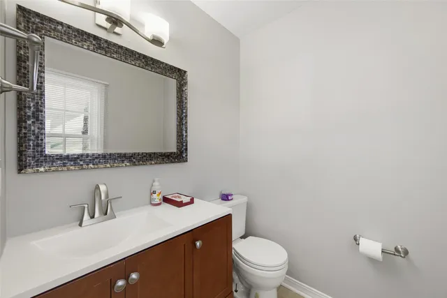 a bathroom with a granite countertop sink mirror and toilet