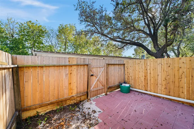 a view of a backyard with potted plants and wooden fence