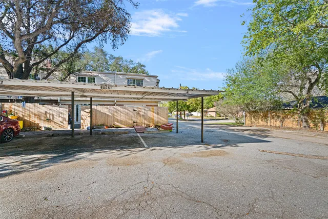 a view of a house with a yard and table and chairs under an umbrella