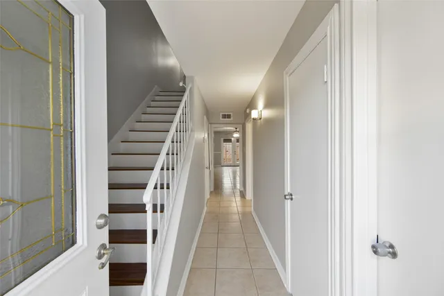 a view of hallway with stairs and wooden floor