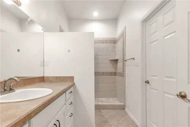 a bathroom with a granite countertop sink a mirror and shower