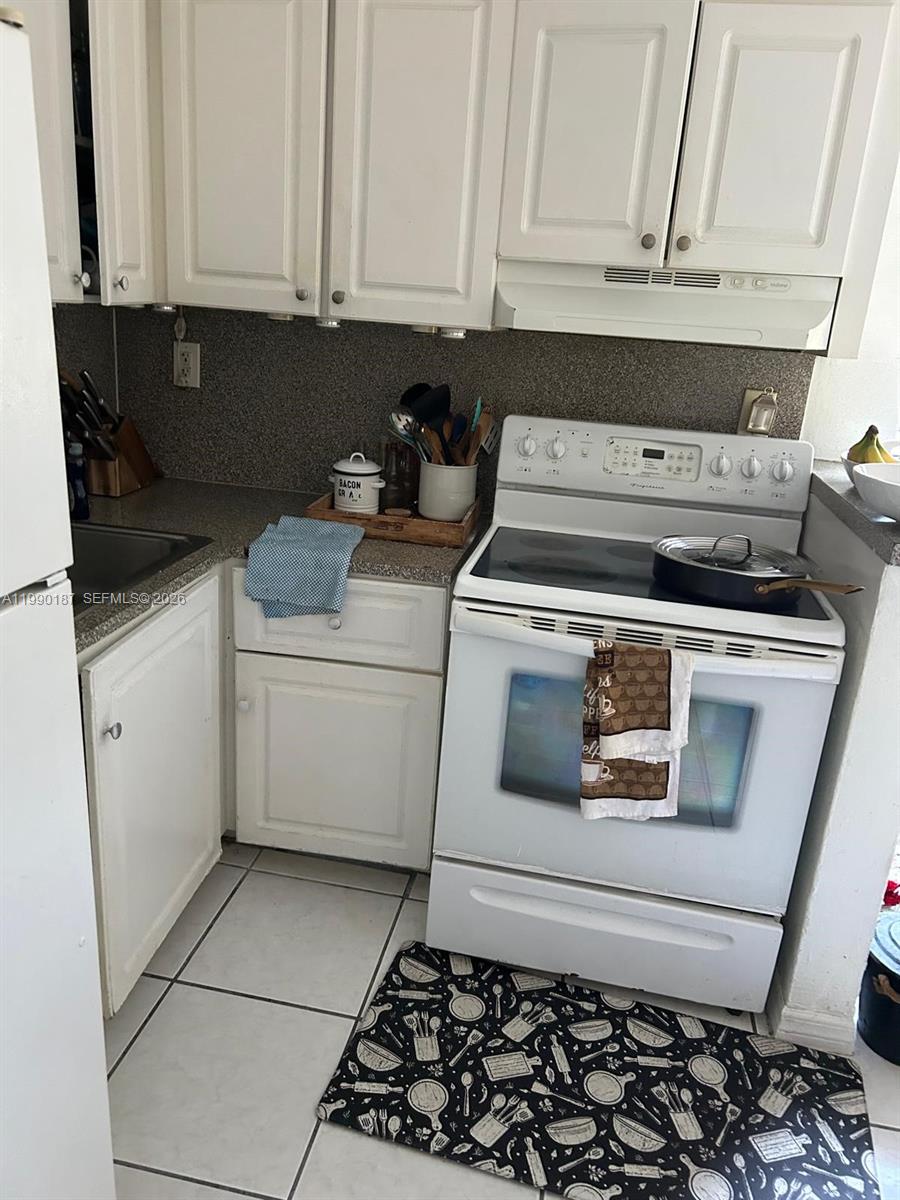 11 Southwest 32nd Avenue, Unit 4 Miami, FL 33135 - Photo 4 of 10 a kitchen with a stove and white cabinets