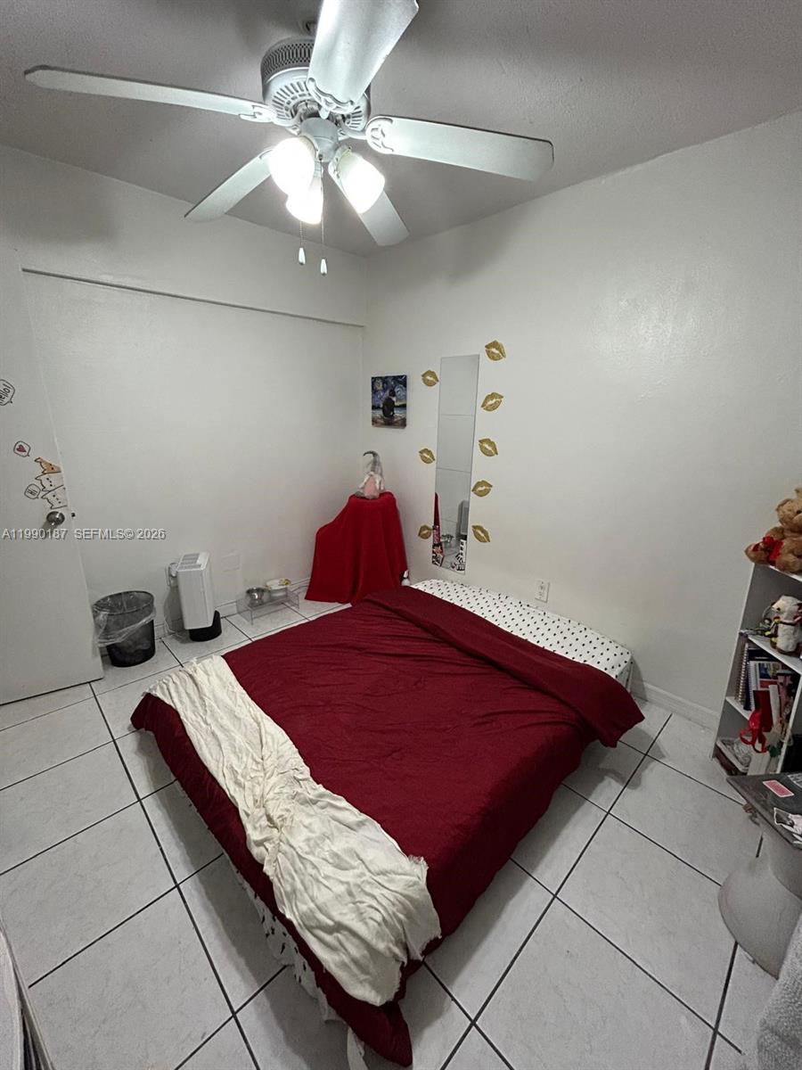 11 Southwest 32nd Avenue, Unit 4 Miami, FL 33135 - Photo 7 of 10 a bedroom with a bed and a chandelier