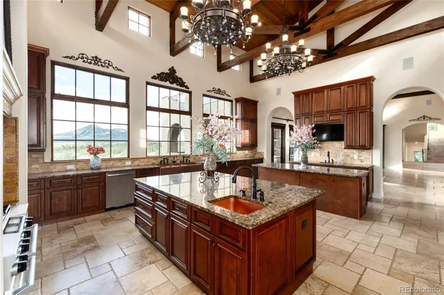 a large kitchen with kitchen island granite countertop a large counter top and stainless steel appliances