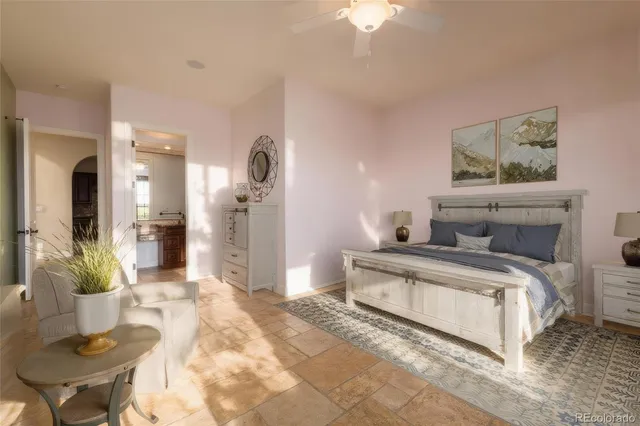 a spacious bedroom with a bed and a chandelier